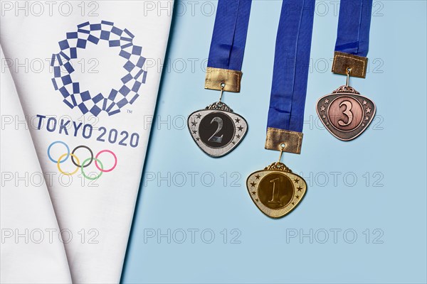 Tashkent, Uzbekistan - March 4, 2021: 2020 Summer Olympic Games logo on white towel and Golden, Silver and Bronze olympic medals