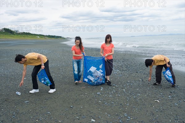 Young people cleaning beach