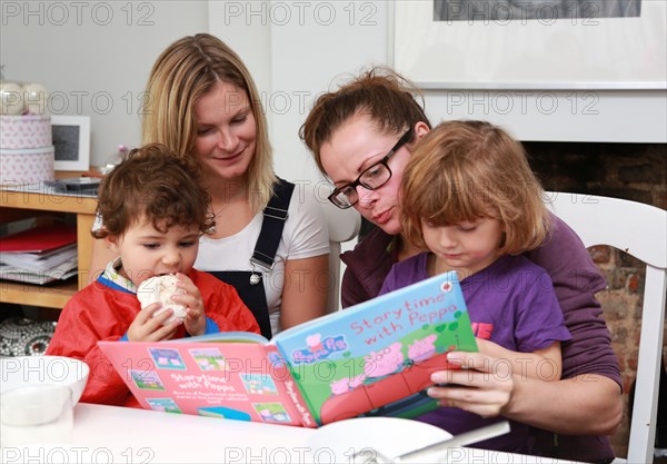 2 women reading to their kids