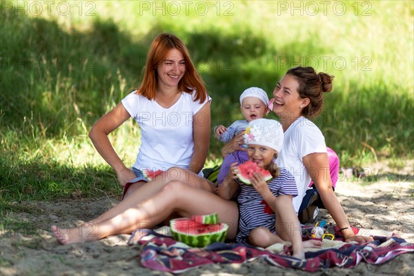 Concept for togetherness and bright future.Two beautiful women with a baby on the picnic  in park at  during vacation  Couple lovers woman smile and e