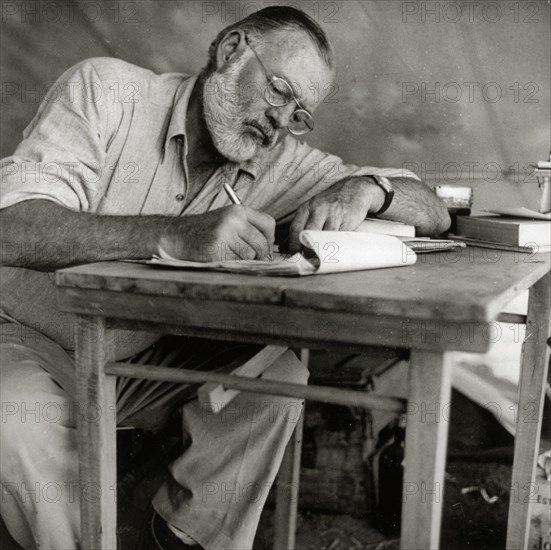 Ernest Hemingway Writing at Campsite in Kenya, circa 1953  File Reference # 1003_427THA