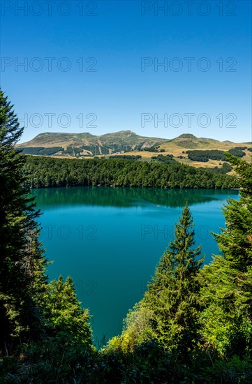 View on Volcanic lake of Pavin located in the Regional Natural Park of Auvergne Volcanoes, Sancy massif in the background, Auvergne, France, Europe