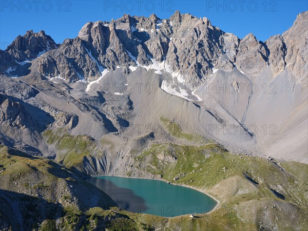 AERIAL VIEW - Lac Sainte-Anne, a glacial lake (alt: 2414m) at the foot of  pics de la Font Sancte (alt: 3385m). Ceillac, Hautes-Alpes, France.