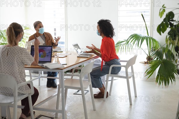 Office colleagues wearing face mask talking at office