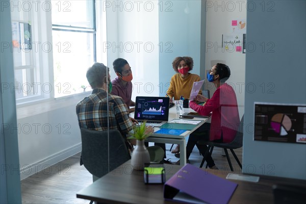 Diverse group of work colleagues wearing masks in an office