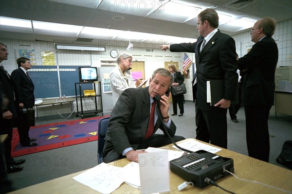 As Dan Bartlett, Deputy Assistant to the President, points to news footage of the World Trade Center Tuesday, Sept. 11, 2001, President George W. Bush gathers information about the terrorist attack from a classroom at Emma E. Booker Elementary School in Sarasota, Fla. Also pictured from left are: Deborah Loewer, Director of White House Situation Room, and Senior Adviser Karl Rove. Photo by Eric Draper, Courtesy of the George W. Bush Presidential Library