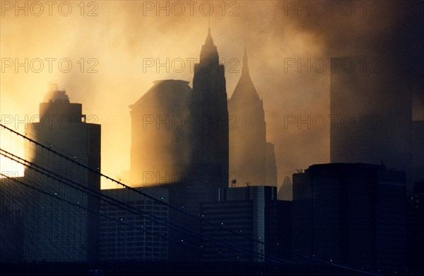 Sunset through the smoke of the WTC terrorist bombings of September 11 2001 frames the skyscrapers of lower Manhattan