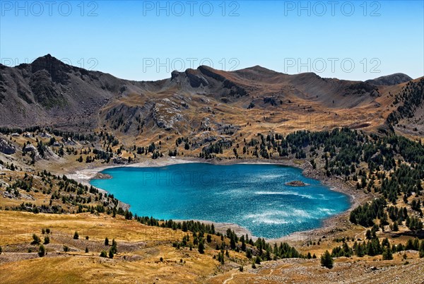 Image of Lac D'Allos (2228 m) during a windy day with sunlight reflections on the rippled water surface.