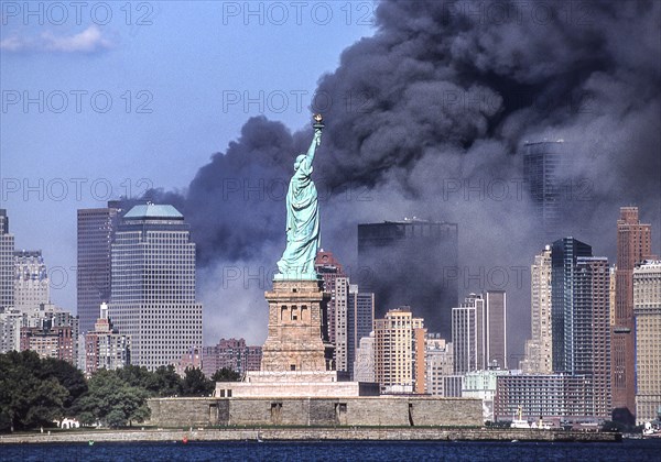 Sept. 11, 2001 - New York, New York, US - The Statue of Liberty stands against the backdrop of billowing clouds of smoke and debris over lower Manhattan after terrorists crashed two hijacked airliners into the World Trade Center on September 11, 2001, bringing down the twin 110-story towers that used to share the skyline. Photograph taken from an abandoned pier in Jersey City, N.J.The Statue of Liberty stands against the backdrop of billowing clouds of smoke and debris over lower Manhattan after terrorists crashed two hijacked airliners into the World Trade Center on September 11, 2001, bringi