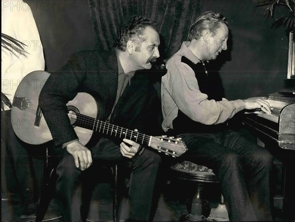 Dec. 12, 1965 - Brassens to sing Trenet's Song: Georges Brassens, the Famous French ' Reacist' Singer is now rehearsing the song written specially for him by another famous singer-composer, Charles Trenet. Photo shows Brassens, Typical with his drooping moustache and ever-present pip~. listening to the tunes played by Charles Trenet.