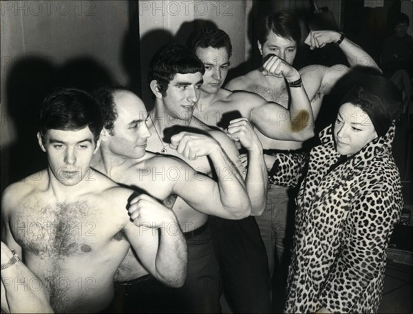 Mar. 03, 1966 - Regine Picks Up Her 'Carriers': Regine, owner of A Paris night Club, will? be one of the attractions at the annual charity show for the Bennett of needy actors. She will appears as the ''MAE West 1966''. Photo Shows Regine inspecting a group of ''Muscle Men'' who will carry her on their shoulder.