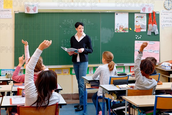 Portrait of diligent schoolkids and their teacher talking at lesson