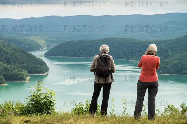 Tourists on the viewpoint on the Lake Vouglans, France, Europe.
