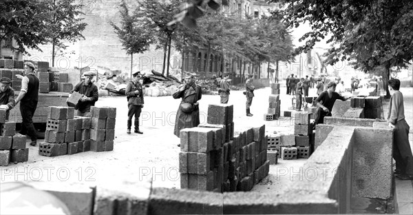 Building the Berlin Wall under armed guard, Berlin, Germany, 1961.