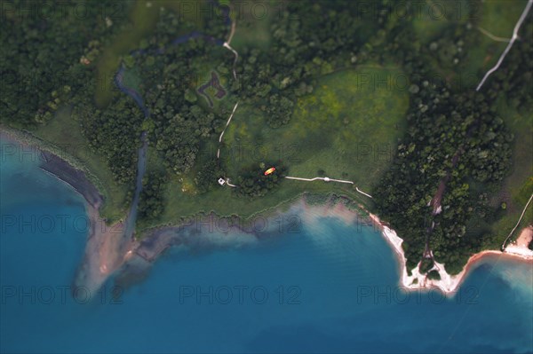 Aerial view of a paraglider flying next to Lake Annecy.