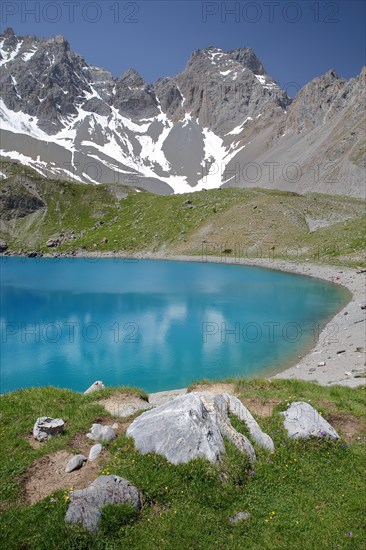 Sainte Anne lake located above Ceillac village after two hours hike, with reflections of mountain range, Queyras Natural Park, Southern Alps, France