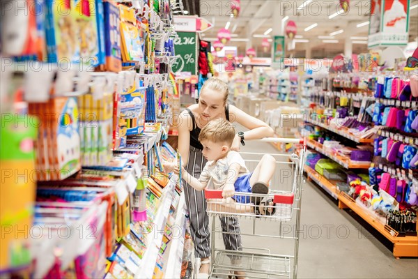 KYIV- JAN 6, 2019: Little boy choosing school supplies with mother in stationery shop