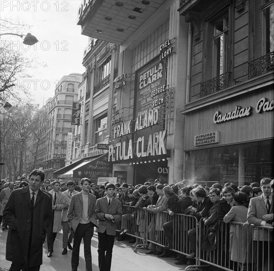 Pariser Bilder [The street life of Paris]  Crowd in front of theatre Olympia is crowding to buy tickets to a Rolling Stones concert Annotation: The Rolling Stones gave on April 16, 17 and 18 1965 concerts at the Olympia. It is not clear whether the photo was taken during the ticket sale, or before the start of the (afternoon) show Date: 1965 Location: France, Paris Keywords: crowd, pop music, street images, theaters