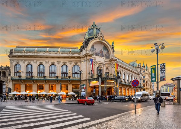 Sun sets in New Town Prague, Czech Republic as locals traverse the main street in front of the Prague Municipal House.