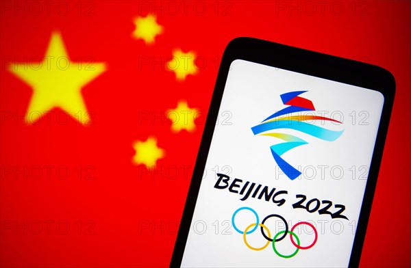 Ukraine. 07th Dec, 2021. In this photo illustration, 2022 Winter Olympics (XXIV Olympic Winter Games or Beijing 2022) logo is seen on a smartphone screen with a flag of China in the background. Credit: SOPA Images Limited/Alamy Live News