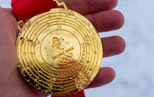 January 4, 2022, Beijing, China. Gold medal of the XXIV Olympic Winter Games in the palm of your hand.