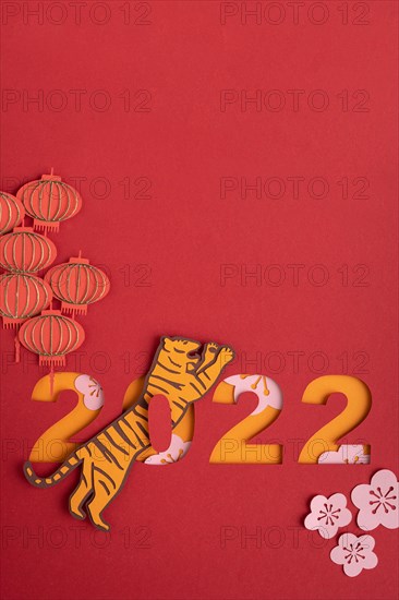 Chinese New Year. Decoration with traditional Chinese New Year motifs, cut out paper decorations on red cardboard background. Copy space.