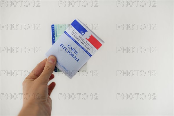 PARIS, FRANCE - MARCH 09, 2020: Hand holds a french electoral card and an identification card for voting