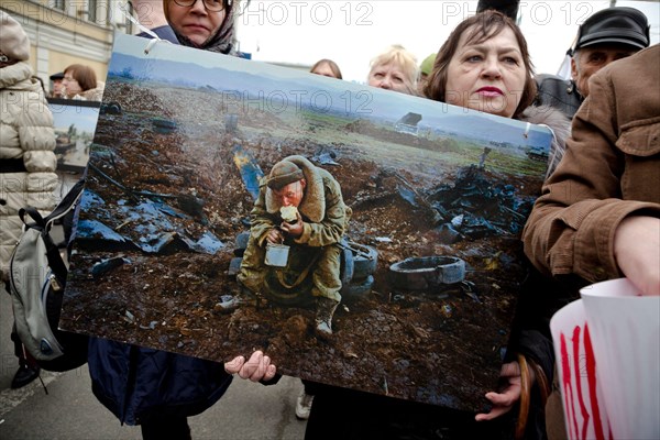 Moscow, Russia. 15th March, 2014 A woman holds a banner with a photo of Vladimir Vyatkin photographer at the action "One Second of War" as part of the Peace March along the boulevards of the central Moscow, Russia. People hold photos of famous Russian documentary photographers (winners of the World Press Photo) during a march against the war with Ukraine