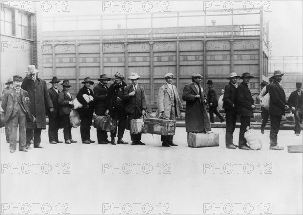 Vintage photo circa 1911 of immigrants queuing up to be processed at Ellis Island in New York.