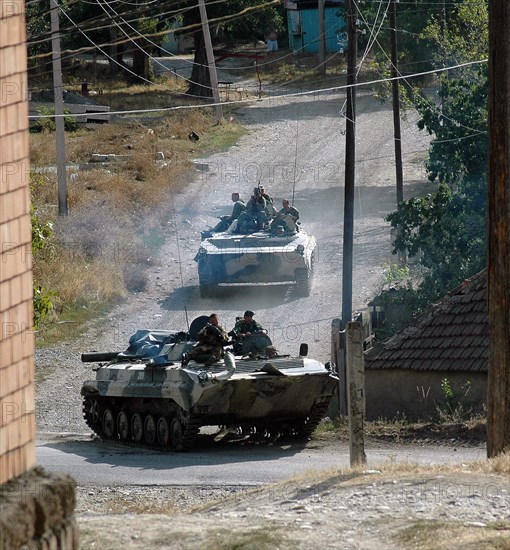 Infantry and armored personnel carriers of Russia's 17th Motor Rifle Division move through the Georgian village Igoeti, 16 August 2008. Russian President Dmitry Medvedev on Saturday signed a ceasefire agreement ending hostilities with Georgia over the breakaway region of South Ossetia. Georgian media reports said that Russian troops in Georgia were making no preparations for withdr