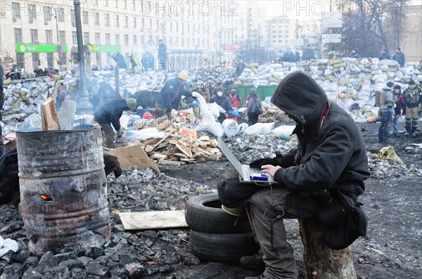 Kiev, Ukraine. 02nd Feb, 2014. A man sits with a laptop near to a fire at the so-called EuroMaidan demonstrations that began after plans for closer integration with Europe were scrapped in November 2013. Credit:  Oleksandr Rupeta/Alamy Live News