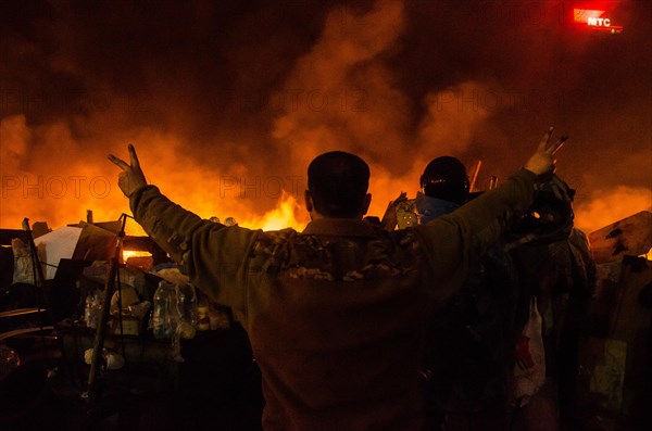 Feb. 20, 2014 - Kiev, Ukraine- February 20, 2014: Midnight on the Maidan, protesters at the barricades singing the Anthem of Ukraine. A barricade is created by protesters made of burning objects. More than 10,000 protesters in Independence Square, Kiev. Regardless of the stage declared truce between police and activists, the people continue to throw molotov cocktails at law enforcement officers. Security forces responded with stun grenades. (Credit Image: © Stas Kozlyuk/NurPhoto/ZUMAPRESS.com) Credit:  ZUMA Press, Inc./Alamy Live News