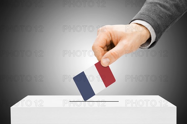 Voting concept - Male inserting flag into ballot box - France