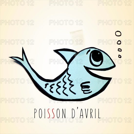 a blue handmade paper fish attached with adhesive tape and the text poisson d avril, april fools day in french