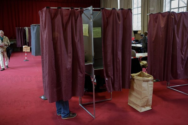 Paris, France. 7th May 2017. A voter makes his decision inside the voting booth. Around 47 Million French people are called to the ballot boxes to elect the next President of France. The independent candidate Emmanuel Macron is expected to take the win over his rival Marine Le Pen from the  right wing National Front.