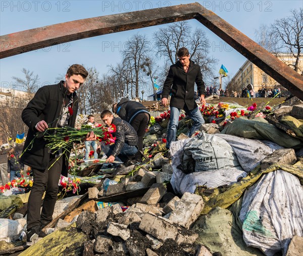 Kiev, Ukraine - February 26, 2014:  Men with flowers on barricade in Kiev on Maidan Square during the revolution in the Ukraine.