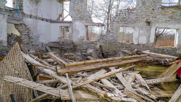 Lots of wooden rubbles on the floor of the house that was damaged during the war in ukraine