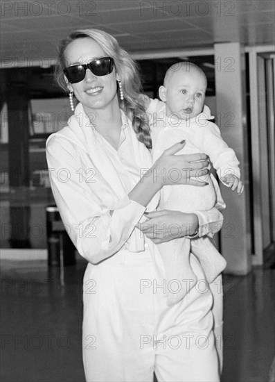Texan model and wife of Mick Jagger, Jerry Hall leaving London's  Heathrow Airport with baby daughter Elizabeth in August 1984.