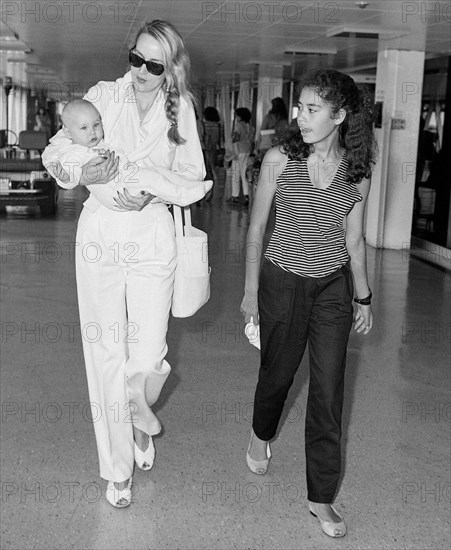 Texan model and wife of Mick Jagger, Jerry Hall leaving London's  Heathrow Airport with baby daughter Elizabeth in August 1984.