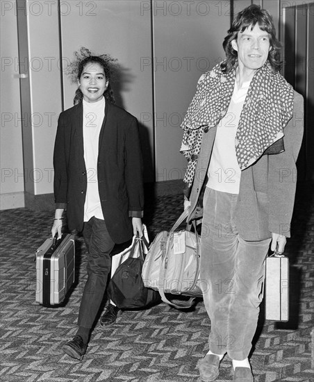 Rolling Stone Mick Jagger with his daughter Karis arriving at London's Heathrow Airport in December 1986.