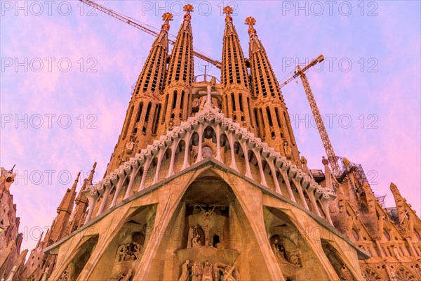 Sagrada Familia - A close-up wide-angle view of west Passion facade of Basílica de la Sagrada Família, against colorful Autumn sunset sky. Barcelona.