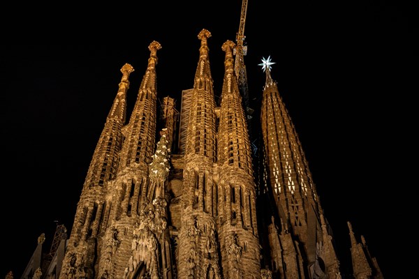 Façana del Naixement (Facade of the Birth) and the star of the Mary tower illuminated at night in the Sagrada Familia (Barcelona, Catalonia, Spain)