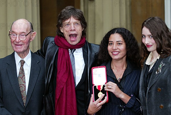 Mick Jagger December 2003 Rollign STones member collects his knighthood from Prince Charles at Buckingham Palace with his father dad Joe Jagger 92 and daughter s Karis Jagger holding medal and Elizabeth Jagger right NB this picture is not sharp Mike Moore