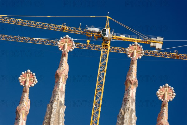 Detail of spires and cranes Sagrada Família church designed by modernista architect Antoni Gaudí Barcelona Spain