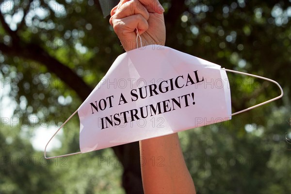 Pro-choice activist holds a coat hanger at a rally at Texas Capital protesting new law relating to abortion restrictions