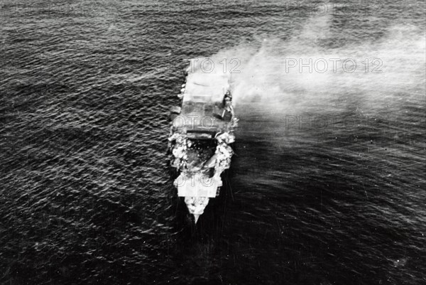 The burning Japanese aircraft carrier Hiryu, photographed by a Yokosuka B4Y aircraft from the carrier Hosho shortly after sunrise on 5 June 1942. Hiryu sank a few hours later. Note the collapsed flight deck over the forward hangar.  Battle of Midway