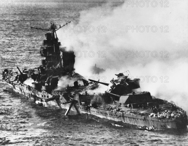 The burning Japanese cruiser Mikuma, 6 June 1942.Japanese heavy cruiser Mikuma, photographed from a USS Enterprise (CV-6) SBD aircraft during the Battle of Midway, after she had been bombed by planes from Enterprise and USS Hornet (CV-8). Note her shattered midships structure, torpedo dangling from the after port side tubes and wreckage atop her number four eight-inch gun turret. 6 June 1942 - Battle of Midway