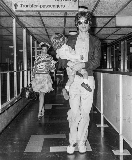 Rolling Stones lead singer Mick Jagger with his wife Bianca and daughter Jade leaving London's Heathrow Airport in 1975.