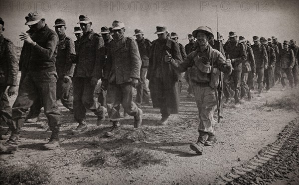 Thumbs up from a British soldier accompanying some of the thousands of German prisoners following the Allied victory at El Alamein in Egypt  during the  Western Desert Campaign.