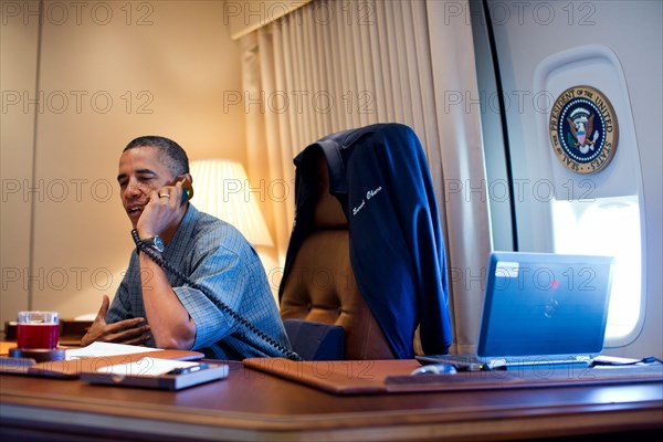 President Barack Obama talks on the phone with NASA's Curiosity Mars rover team aboard Air Force One during a flight to Ouffutt Air Force Base in Nebraska, Aug. 13, 2012.